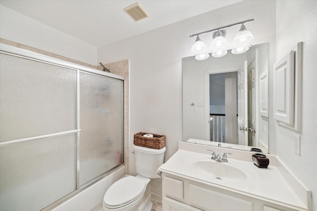 full bathroom featuring toilet, vanity, and shower / bath combination with glass door