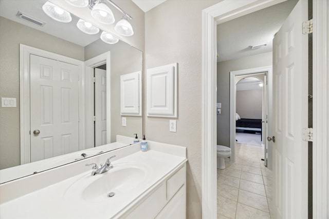 bathroom with toilet, tile patterned flooring, and vanity