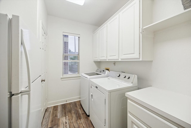 washroom with cabinets, washing machine and clothes dryer, and dark hardwood / wood-style floors