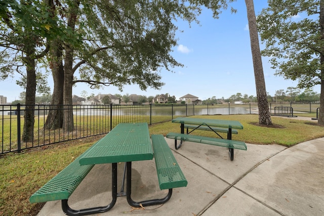 surrounding community featuring a patio, a water view, and a yard