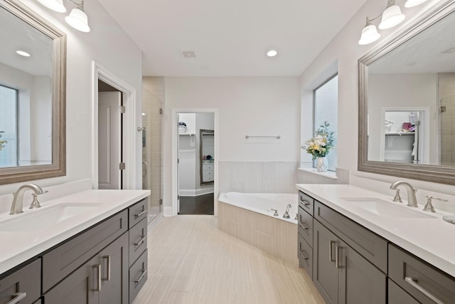 bathroom featuring vanity, plus walk in shower, and a healthy amount of sunlight