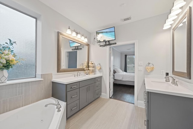 bathroom featuring vanity and a washtub