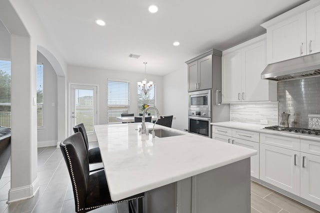 kitchen with sink, stainless steel appliances, and a center island with sink