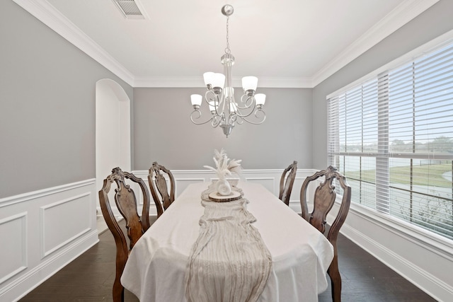 dining area with dark hardwood / wood-style flooring, crown molding, a wealth of natural light, and a chandelier