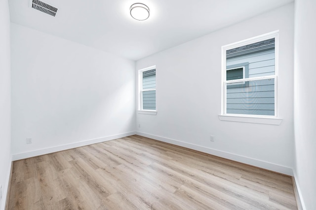 spare room featuring light wood-type flooring and a wealth of natural light