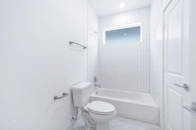 bathroom with toilet and tiled shower / bath