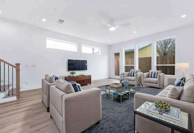 living room with ceiling fan, light wood-type flooring, and plenty of natural light