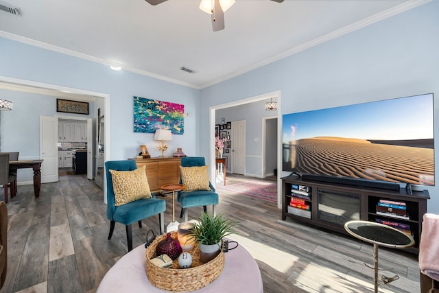 living room featuring ornamental molding, ceiling fan, and wood-type flooring