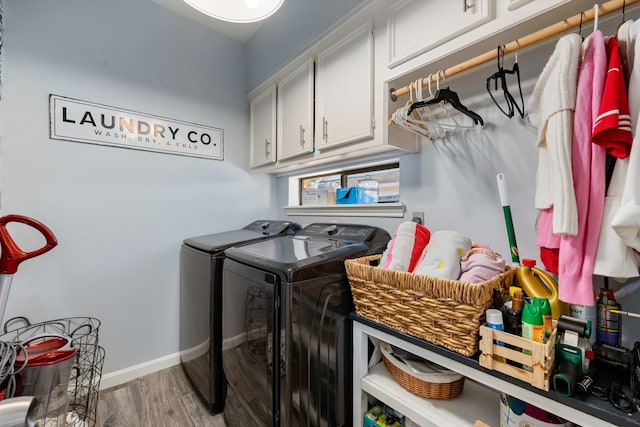 washroom with washer and dryer, cabinets, and light wood-type flooring