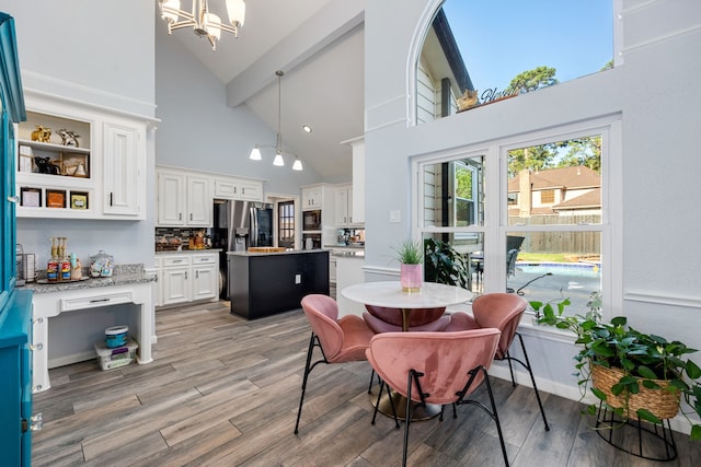 dining area with high vaulted ceiling, a chandelier, light hardwood / wood-style floors, and beamed ceiling