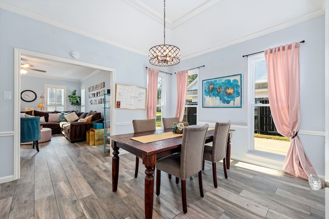 dining space featuring hardwood / wood-style flooring, crown molding, and a wealth of natural light