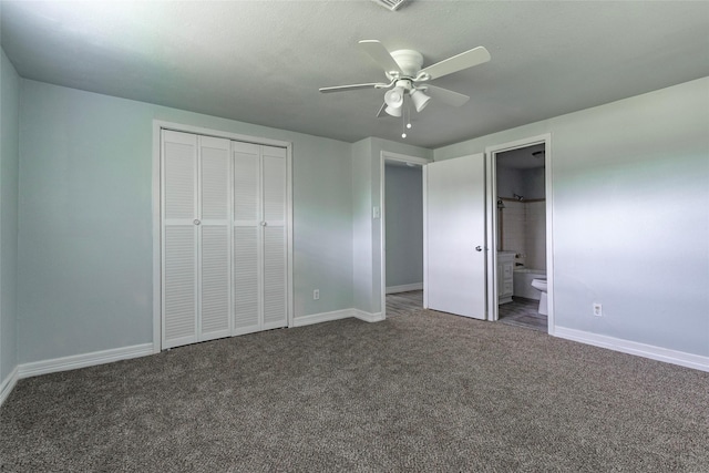 unfurnished bedroom featuring dark colored carpet, ceiling fan, a closet, and connected bathroom