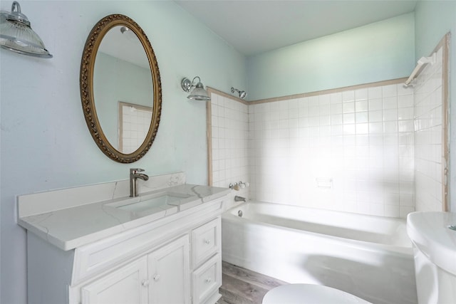 full bathroom with bathtub / shower combination, toilet, vanity, and hardwood / wood-style flooring