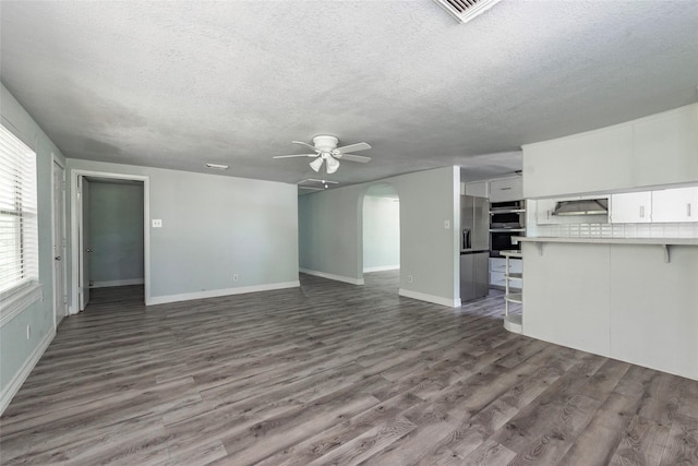 unfurnished living room featuring hardwood / wood-style flooring, a textured ceiling, and ceiling fan