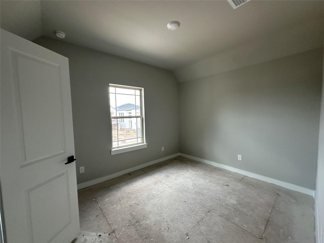 unfurnished room featuring lofted ceiling and baseboards