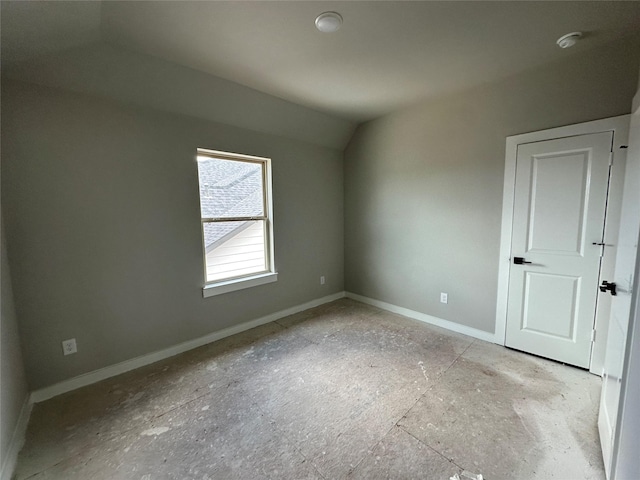 unfurnished bedroom featuring baseboards and vaulted ceiling