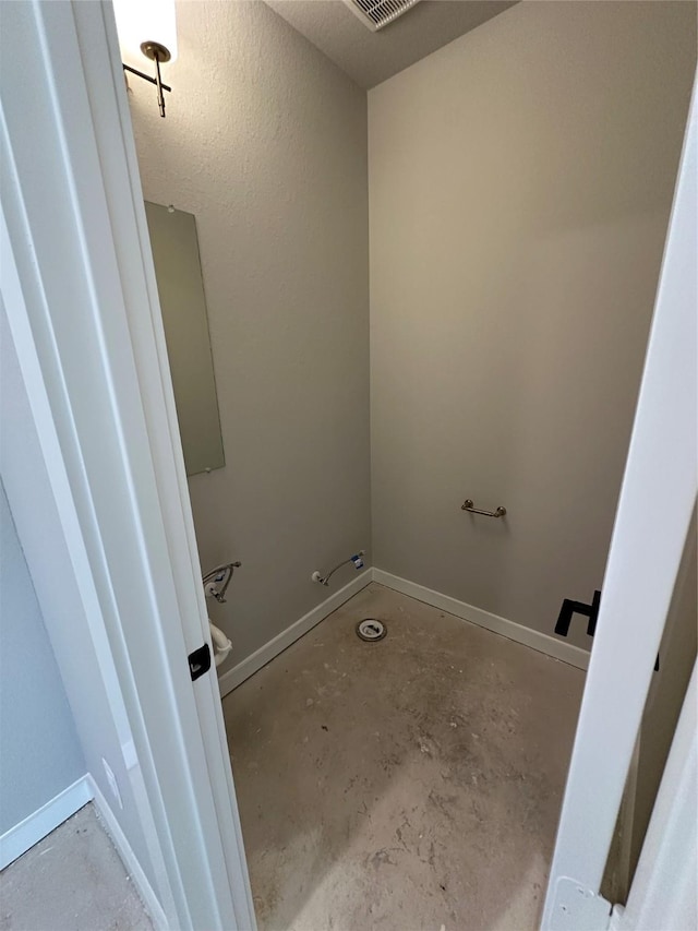 bathroom featuring unfinished concrete floors and baseboards