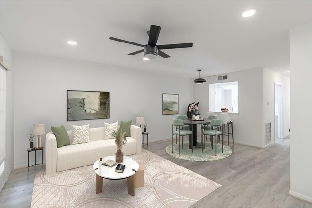 living room with light wood-type flooring and ceiling fan