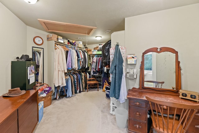 walk in closet featuring light colored carpet