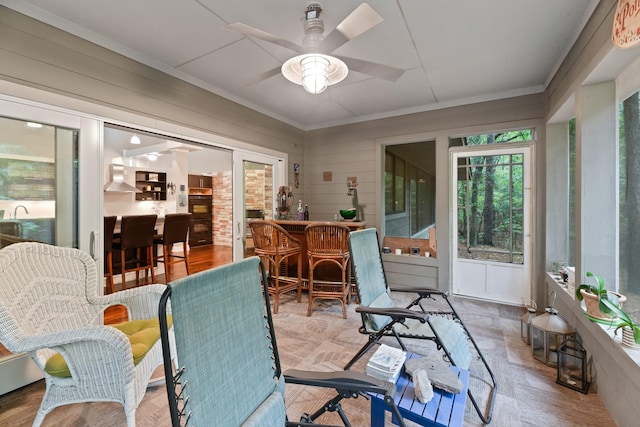 sunroom / solarium featuring ceiling fan