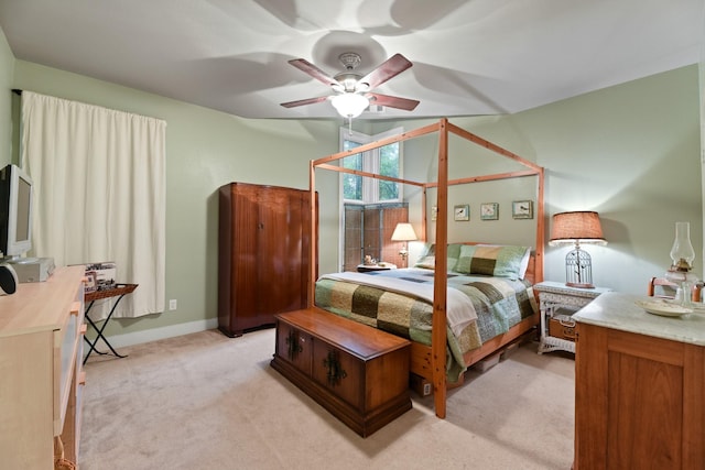 bedroom featuring baseboards, light colored carpet, and a ceiling fan