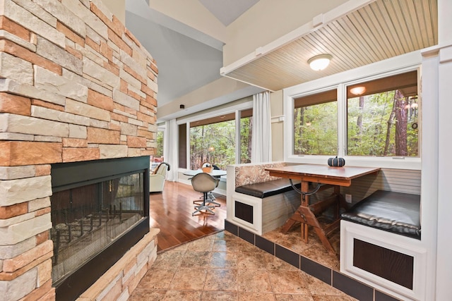 interior space featuring a stone fireplace and vaulted ceiling