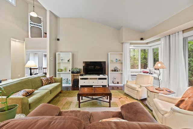 living room with light hardwood / wood-style flooring, plenty of natural light, and high vaulted ceiling