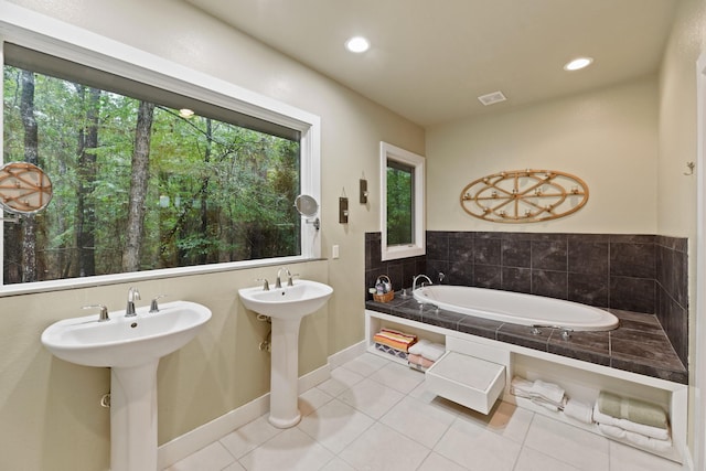 bathroom with tile patterned flooring, baseboards, a garden tub, recessed lighting, and a sink