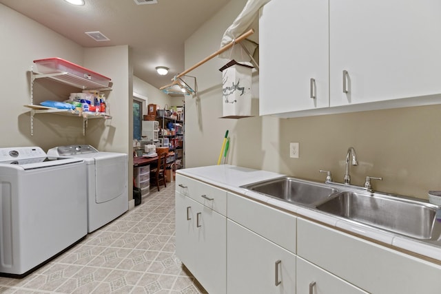 clothes washing area with cabinets, sink, and washing machine and clothes dryer