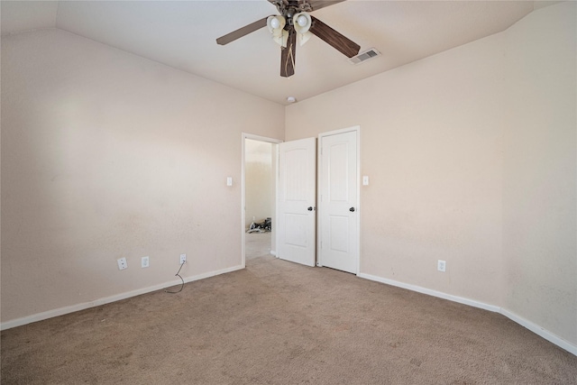 carpeted spare room featuring ceiling fan and lofted ceiling