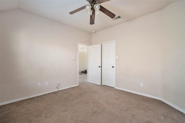 unfurnished bedroom with ceiling fan, visible vents, vaulted ceiling, baseboards, and carpet