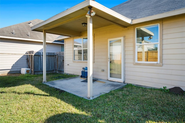 back of property featuring a patio area, fence, a yard, and roof with shingles
