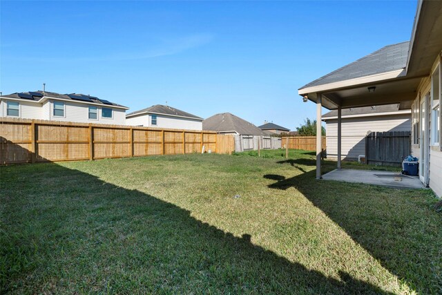 view of yard with a fenced backyard, a patio, and a residential view