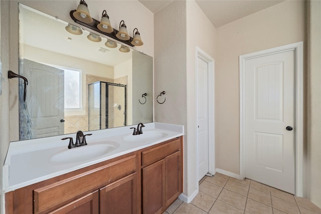 bathroom with an enclosed shower, vanity, and tile patterned flooring