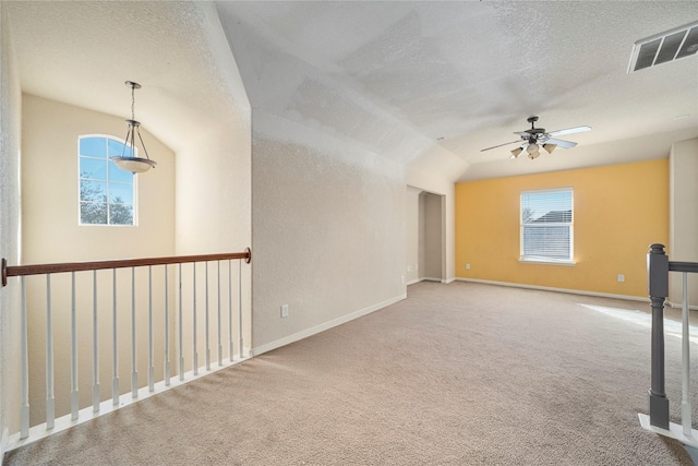 carpeted empty room with a textured ceiling, ceiling fan, and lofted ceiling