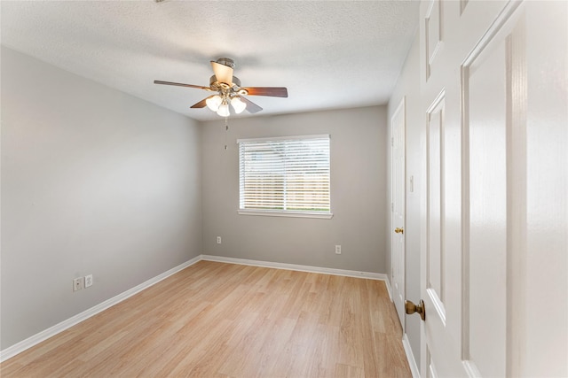 spare room with a textured ceiling, ceiling fan, and light hardwood / wood-style floors