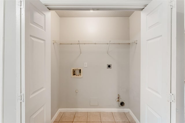 laundry area with light tile patterned floors, electric dryer hookup, hookup for a washing machine, and hookup for a gas dryer