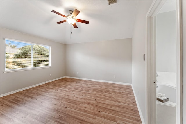 spare room featuring lofted ceiling, ceiling fan, and light hardwood / wood-style flooring