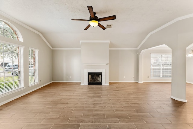 unfurnished living room featuring lofted ceiling, a tiled fireplace, a textured ceiling, and ceiling fan