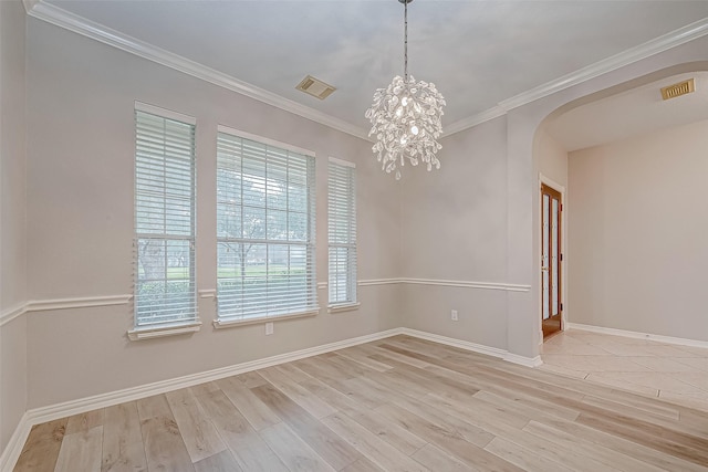 spare room with an inviting chandelier, light wood-type flooring, plenty of natural light, and ornamental molding