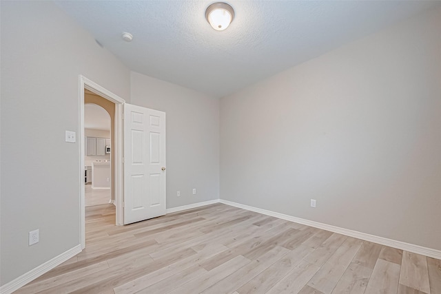 empty room featuring a textured ceiling and light wood-type flooring