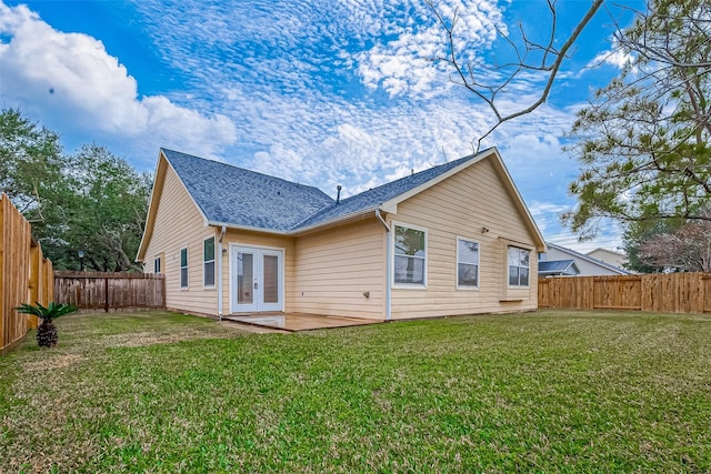 rear view of house with french doors and a yard