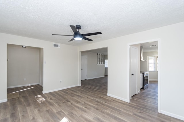 empty room featuring ceiling fan, a textured ceiling, and dark hardwood / wood-style floors