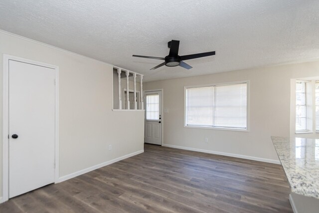 empty room with dark wood-type flooring, a textured ceiling, and ceiling fan