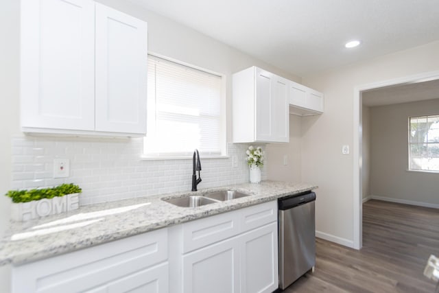 kitchen featuring sink, white cabinets, light stone counters, hardwood / wood-style flooring, and stainless steel dishwasher