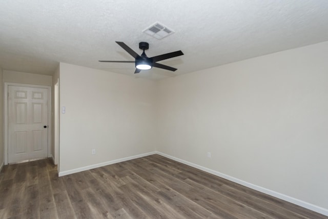 empty room with ceiling fan, dark wood-type flooring, and a textured ceiling