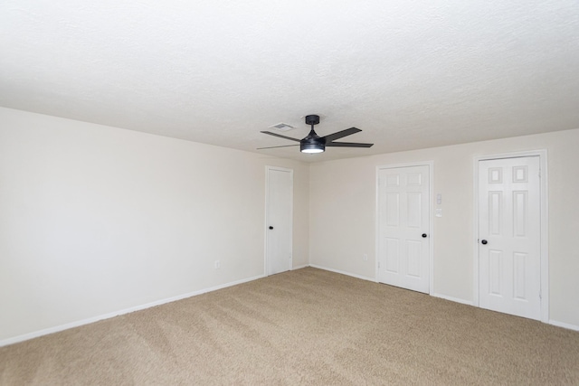 carpeted empty room with a textured ceiling and ceiling fan