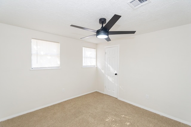 carpeted spare room featuring ceiling fan and a textured ceiling