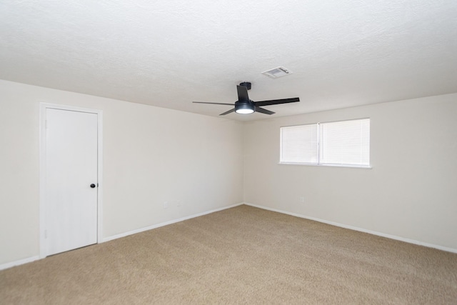 unfurnished room with ceiling fan, light carpet, and a textured ceiling