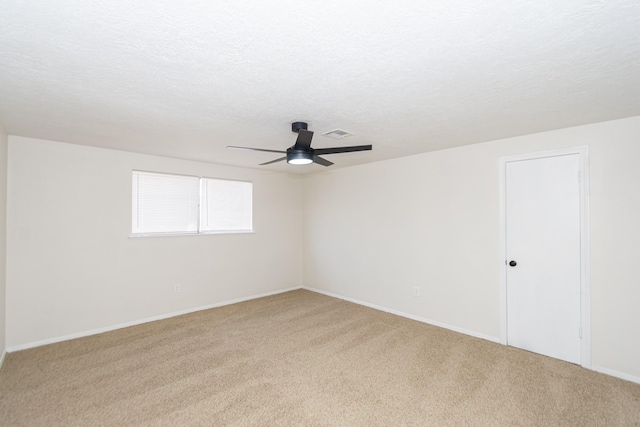 spare room featuring a textured ceiling, carpet floors, and ceiling fan